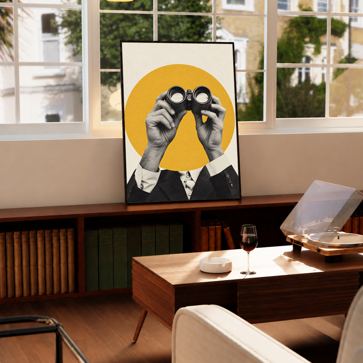 Monochrome hands holding binoculars before a mustard-yellow circle in a black frame by a bright window above a record player