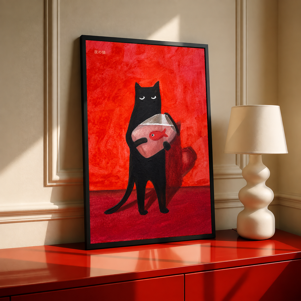Black cat holding a red fish on a red background, in a black frame.
