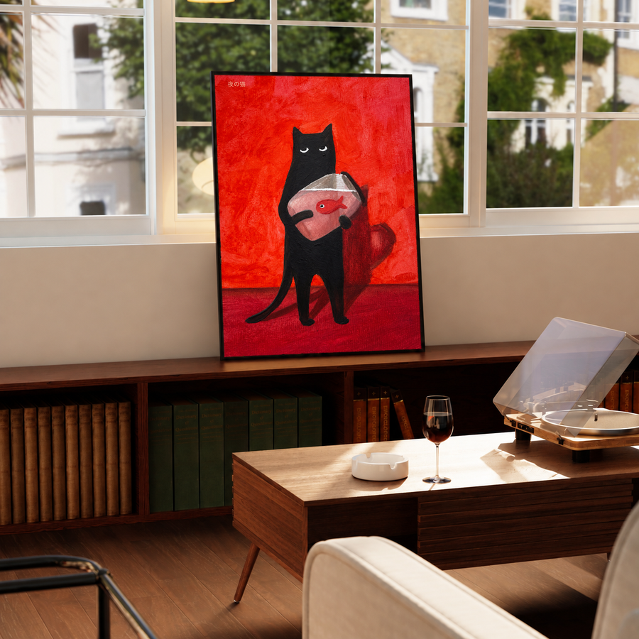 Black cat holding a red fish on a red background, upright framed wall art.