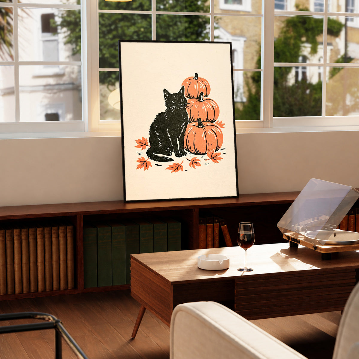 Black-framed autumn linocut art print of black cat with stacked orange pumpkins and leaves