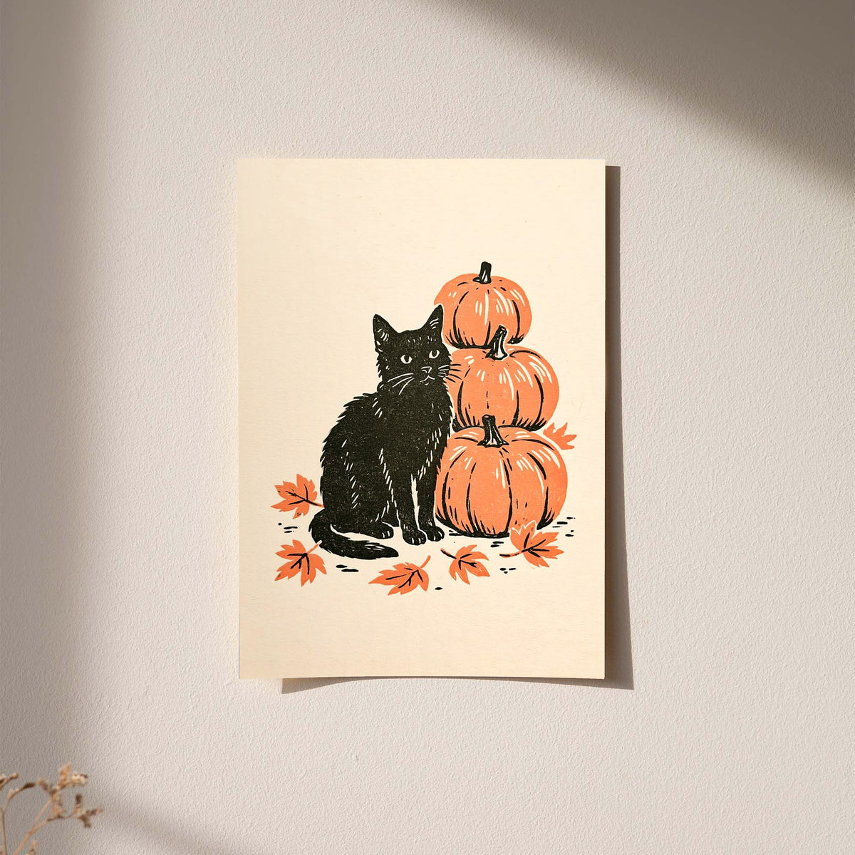 Wall-hung autumn linocut art print of black cat with stacked orange pumpkins