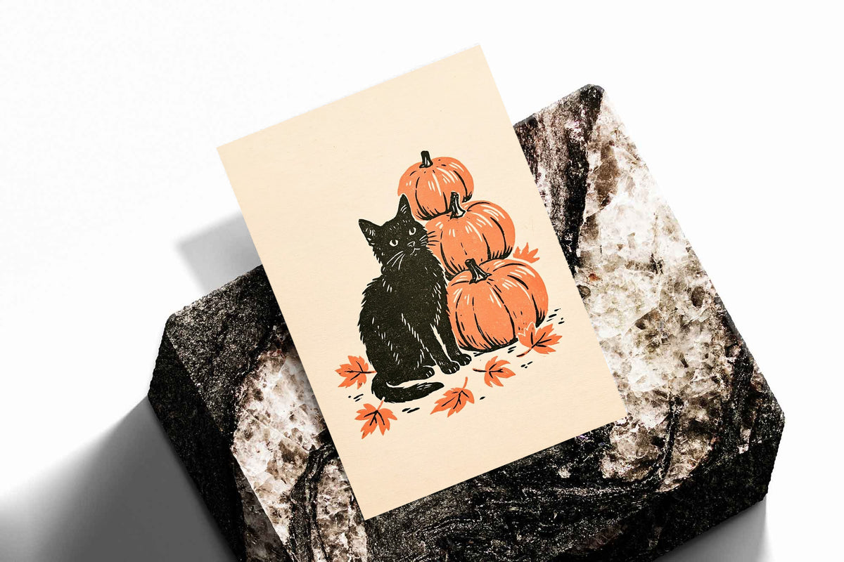 Unframed art print in autumn linocut style: black cat with stacked orange pumpkins