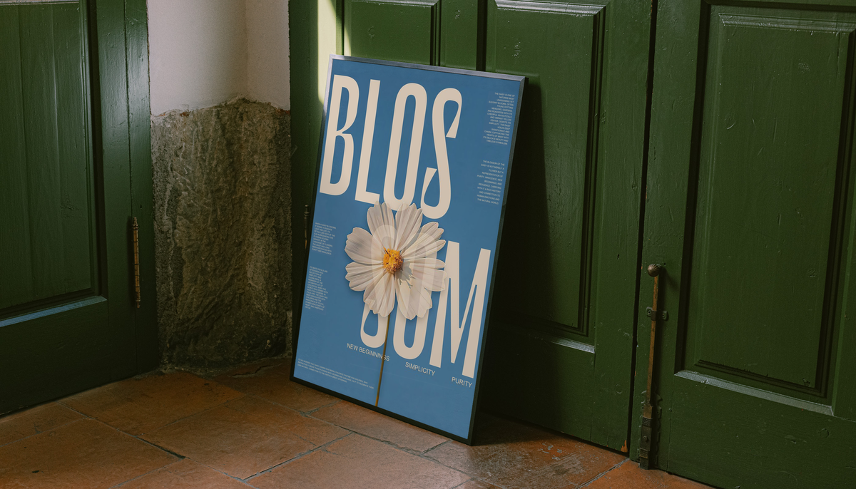 Freestanding framed blue poster with cream lettering and a white daisy flower on a green door