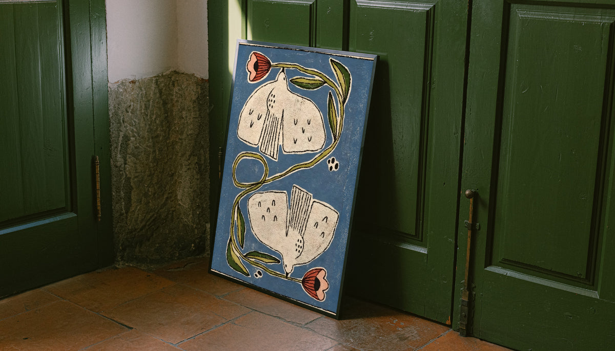 Framed folk floral poster leaning on door: cream flowers, coral buds, green curving stems