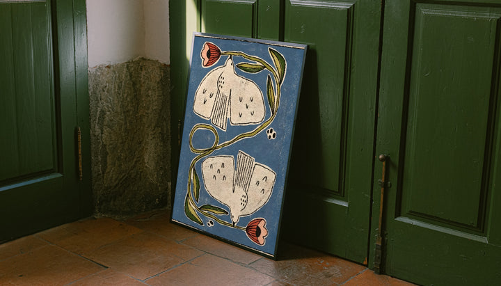 Framed folk floral poster leaning on door: cream flowers, coral buds, green curving stems