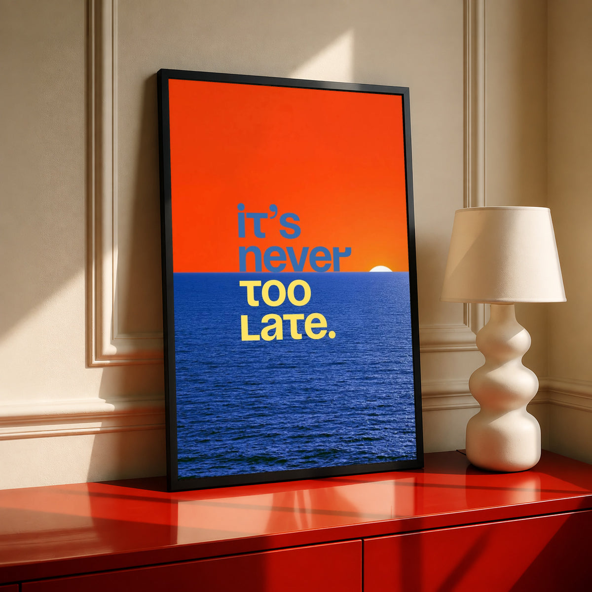 Black-framed ocean quote poster with orange sky and blue sea, “It’s never too late.”