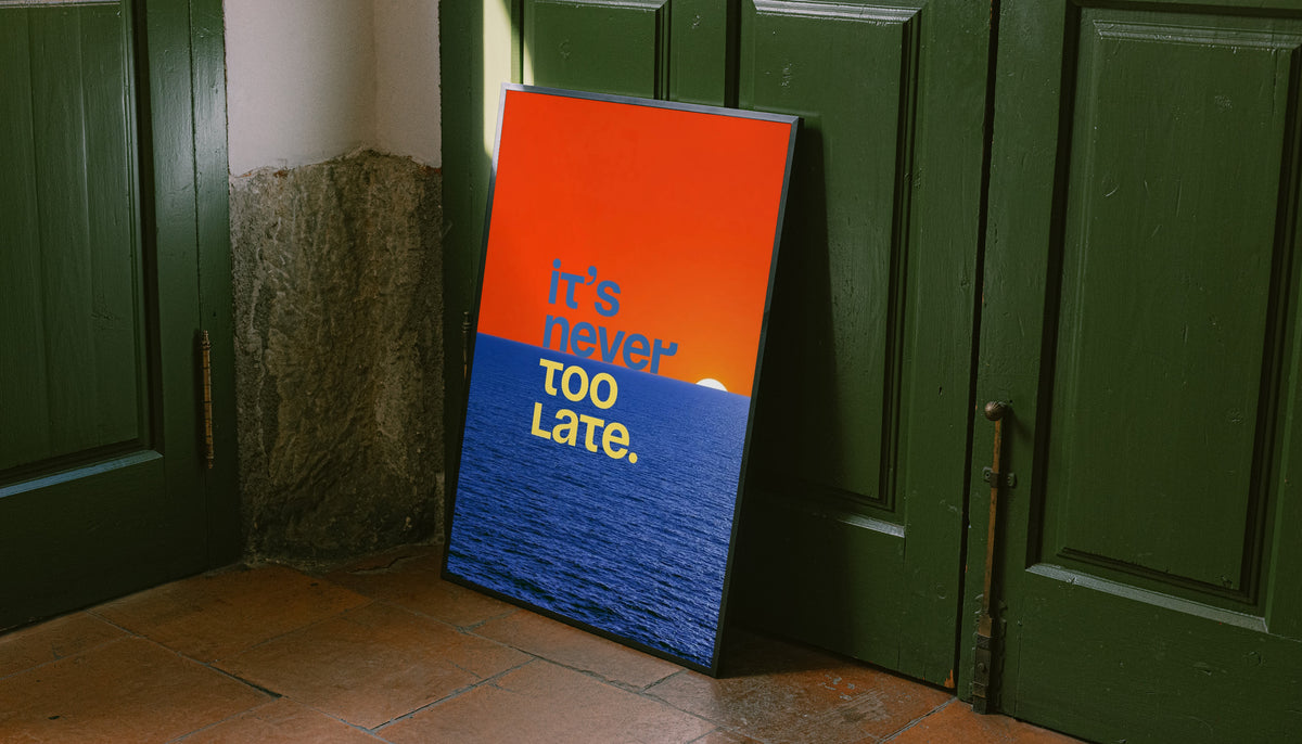 Dark-framed ocean quote poster with orange sunset sky and “It’s never too late.” text