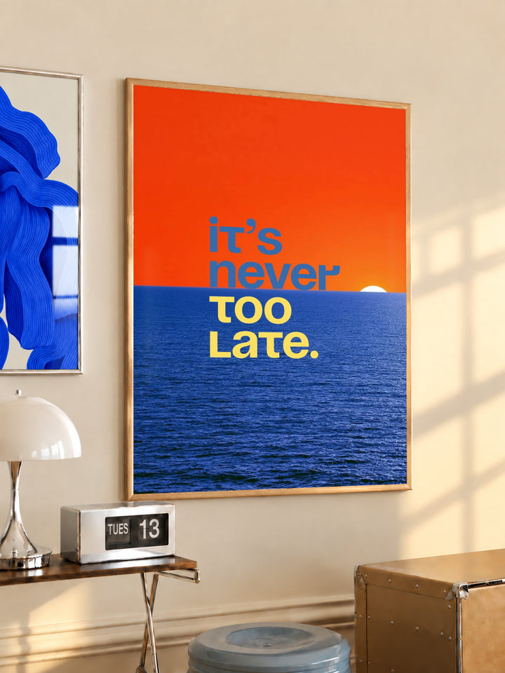 Framed ocean quote poster with orange sky, blue sea, and text “It’s never too late.”