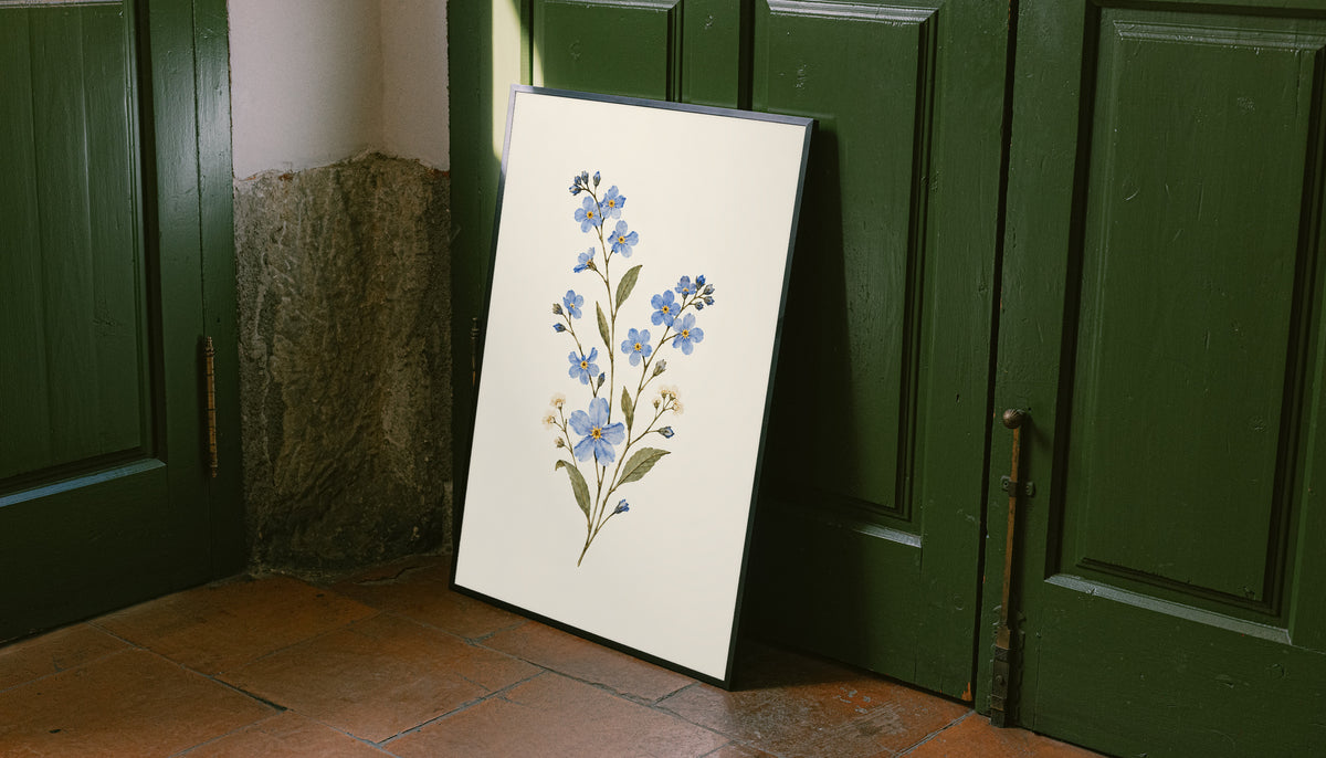 Blue wildflower sprig with small white flowers and olive green leaves as an unframed print leaning against a green panelled door