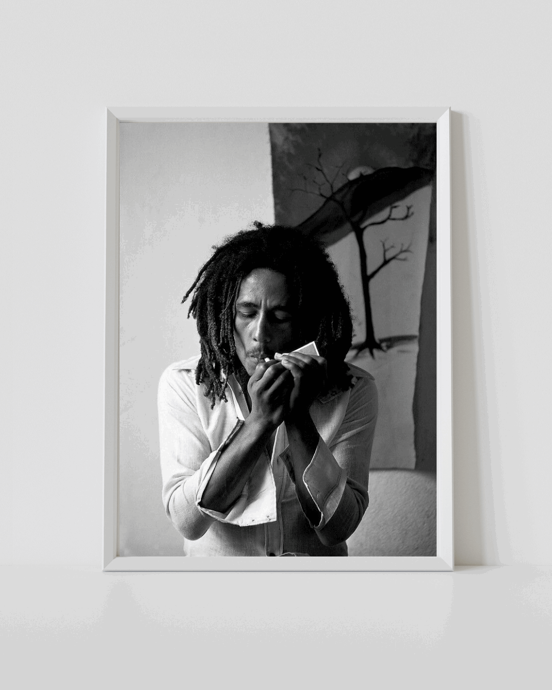Bob Marley black-and-white portrait poster in white frame, person holding microphone