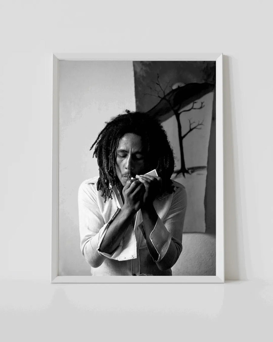 Bob Marley black-and-white portrait poster in white frame, person holding microphone