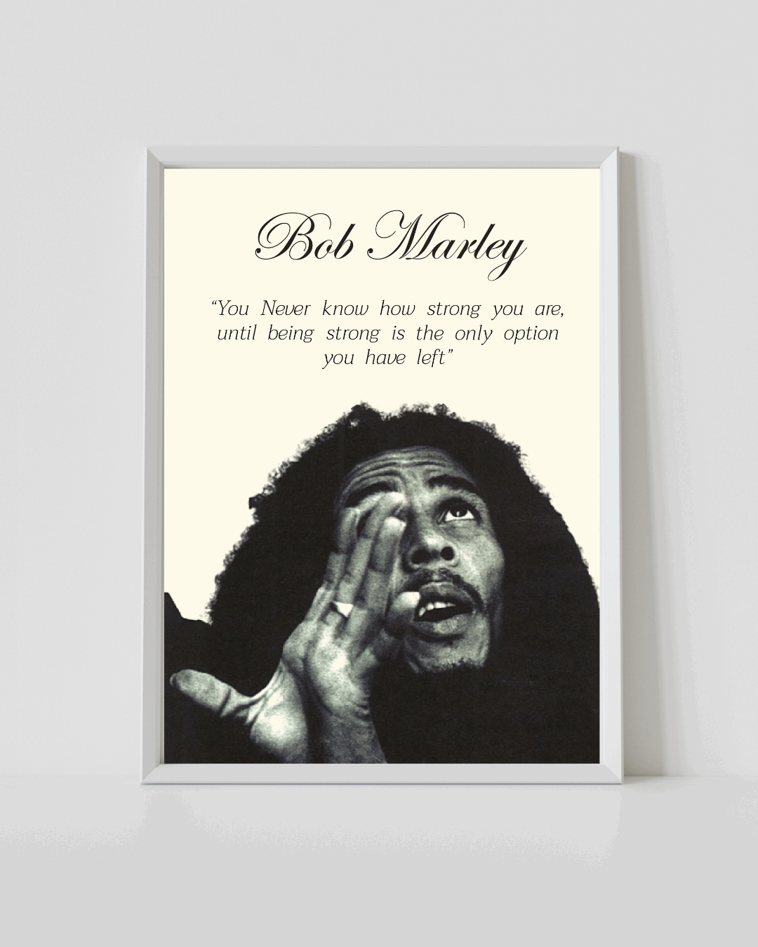 Bob Marley poster in white frame with black-and-white portrait and quote