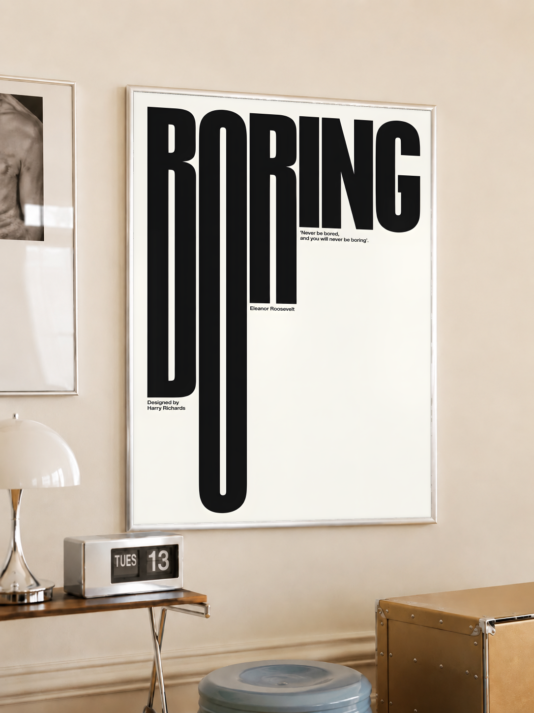 White-framed typography poster: black BORING text on cream background