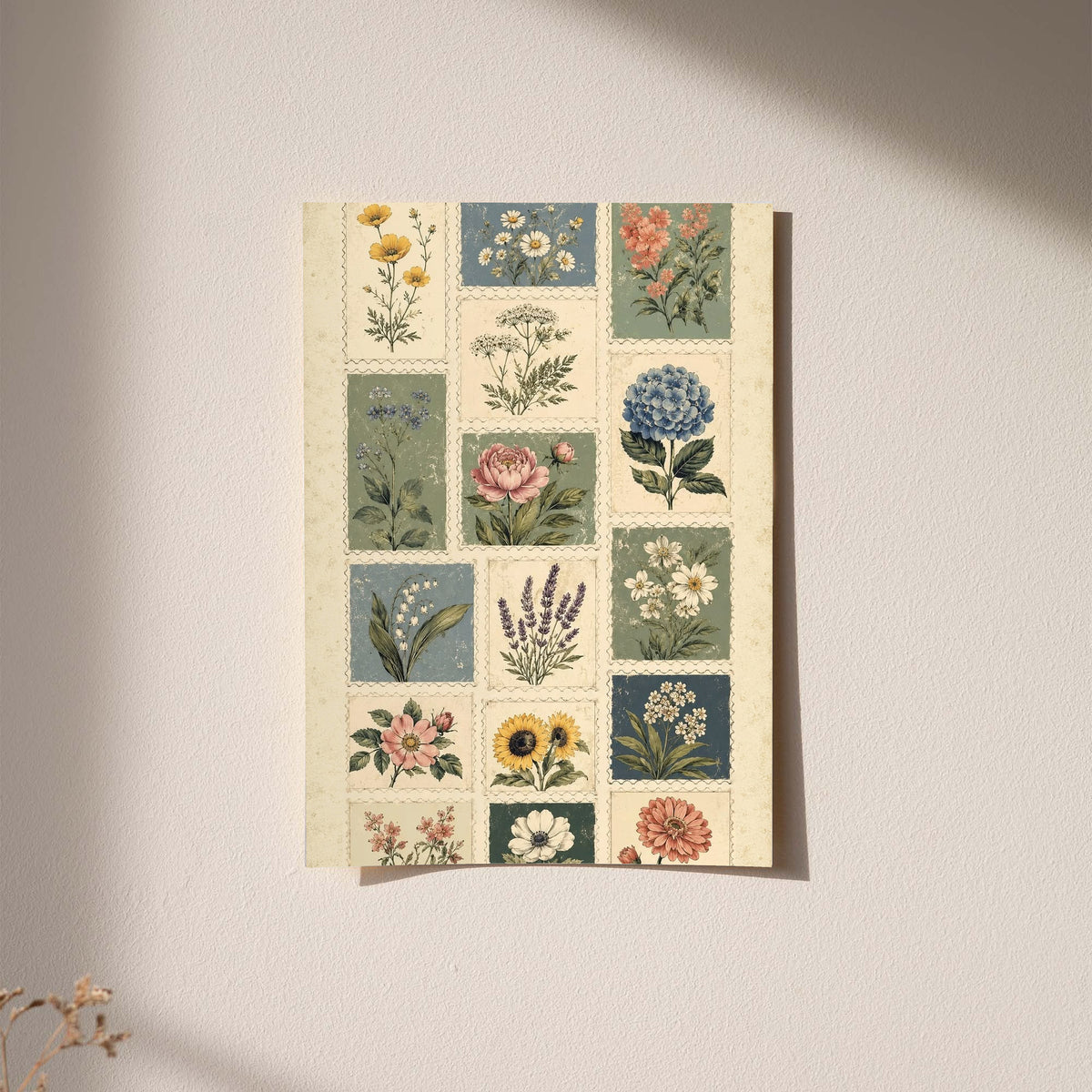 Patchwork of flower and leaf stamp style panels in sage blue pink and cream as an unframed hanging paper print against a plaster wall