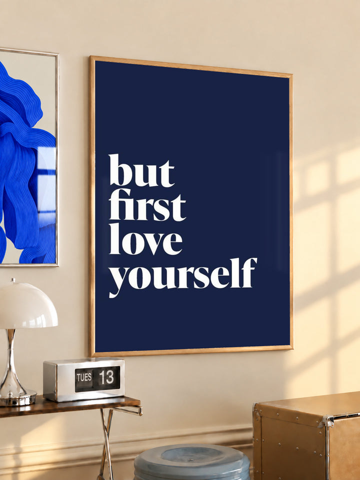 Navy blue framed poster with white serif quote "but first love yourself"
