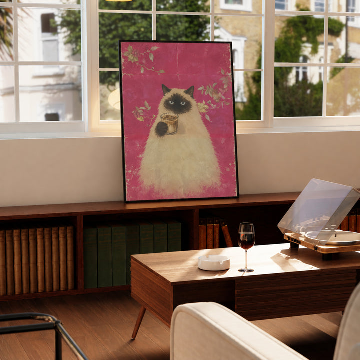 Framed cat holding a cup of coffee on pink floral background