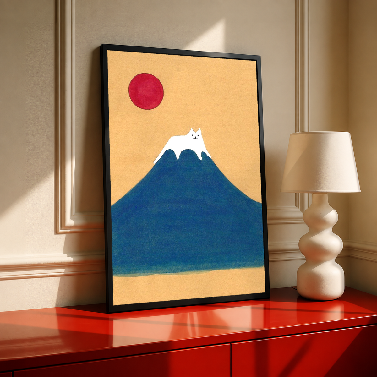 Black-framed mountain art print with red sun and white cat