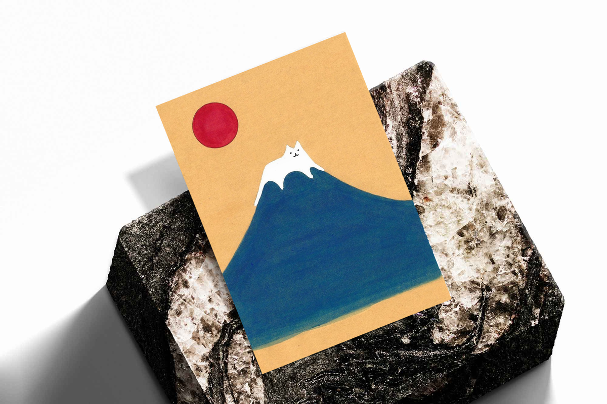 Small art print with blue mountain, red sun, and white cat on stone