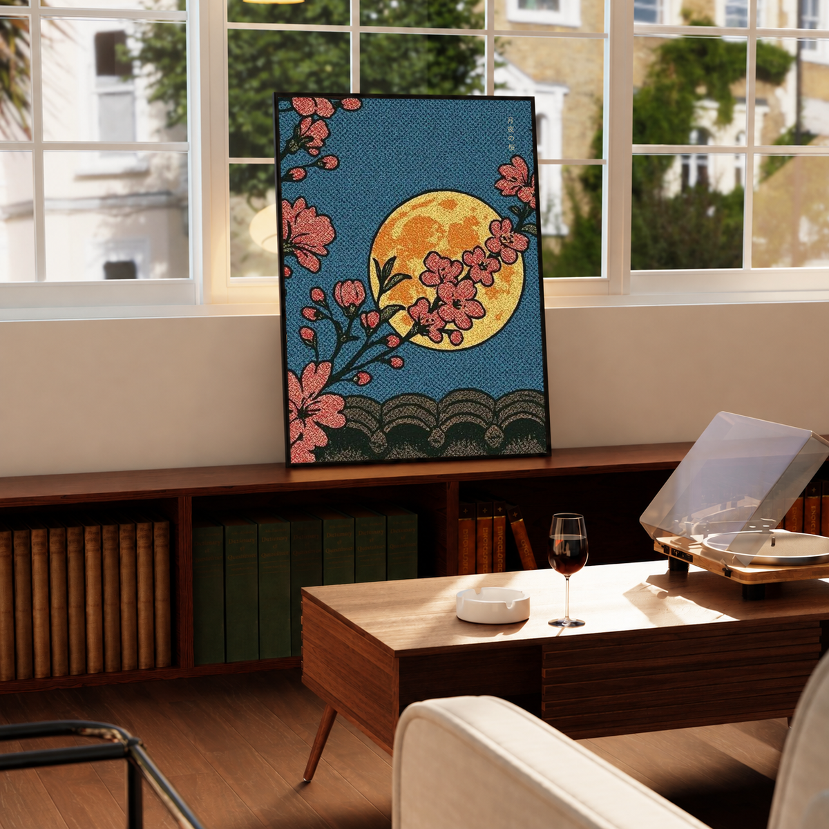 Cherry blossoms, yellow moon and patterned waves in a black frame on a windowsill above a green radiator, with a turntable nearby