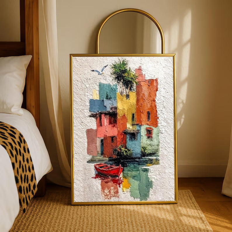 Colorful waterfront houses reflected in green water beside a small red boat in a gold-tone styling frame leaning beside a bedroom mirror