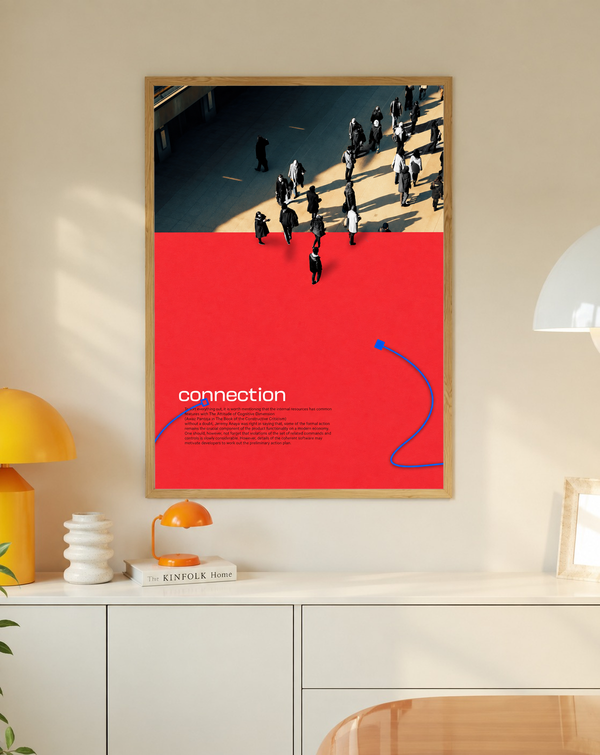 Street pedestrians above a red field with Connection text and two blue cable shapes in a slim oak frame on a cream wall above a white cabinet