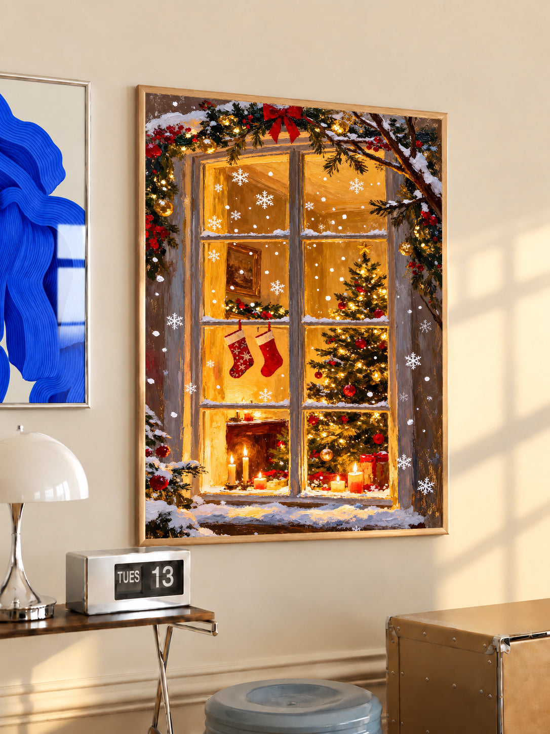 Christmas window art print in a light wood frame, with stockings, a tree, and fireplace
