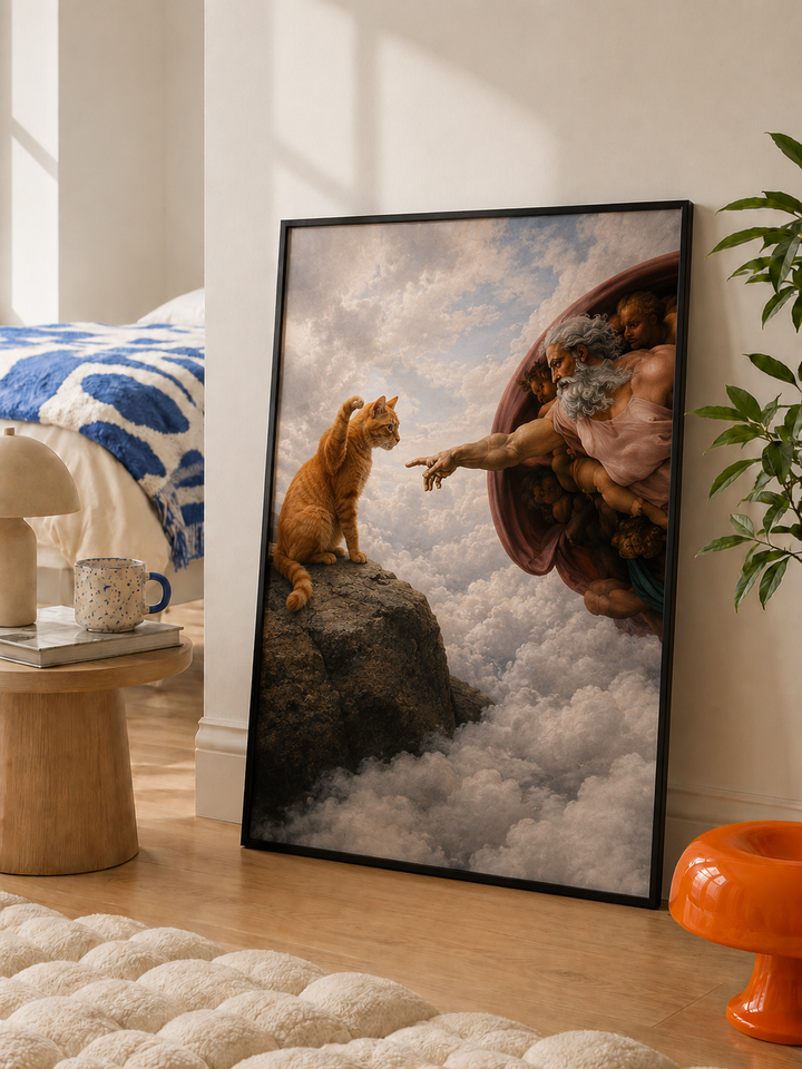 Black-framed cat and Adam-inspired wall art print with figures reaching on clouds