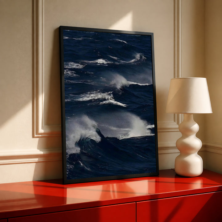 Black-framed dark blue ocean waves wall art with white crests and gray mist