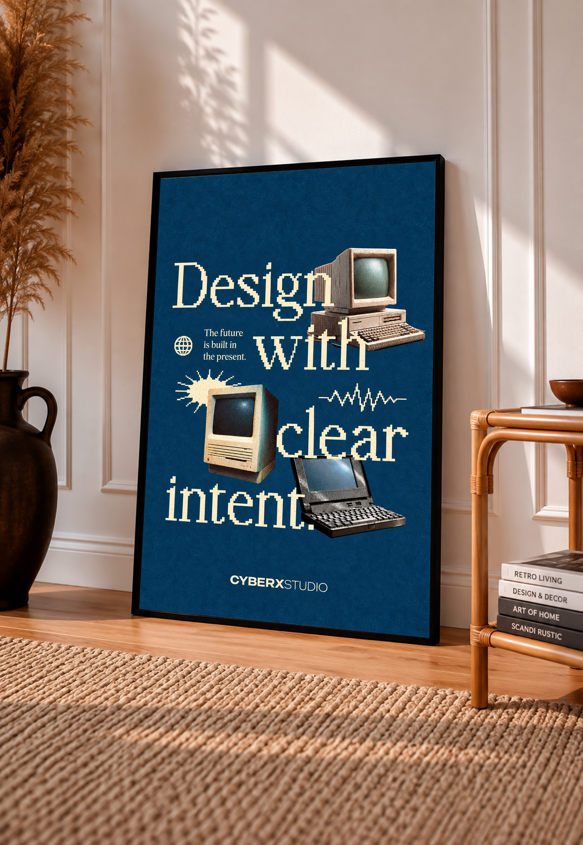 Vintage desktop computers and a laptop with cream pixel-style typography on blue in a black frame leaning on a sunlit floor beside a rattan chair