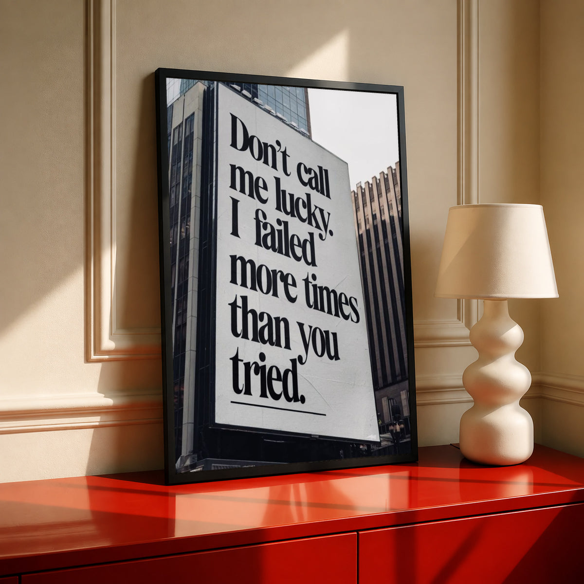 Black-and-white quote poster in dark frame, shown standing on a console table