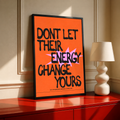 Orange poster with black border and bold quote text, stacked letters in black and pink