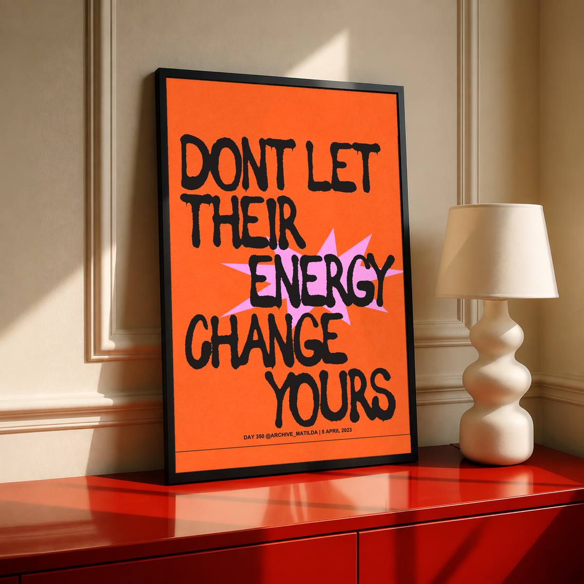 Orange poster with black border and bold quote text, stacked letters in black and pink