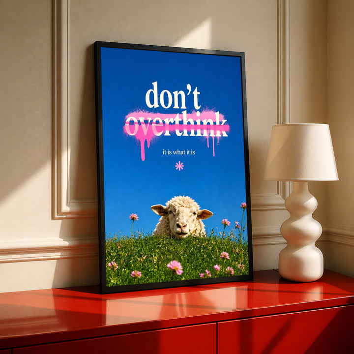 Framed blue meadow wall art with sheep, pink flowers, and “don’t overthink” quote