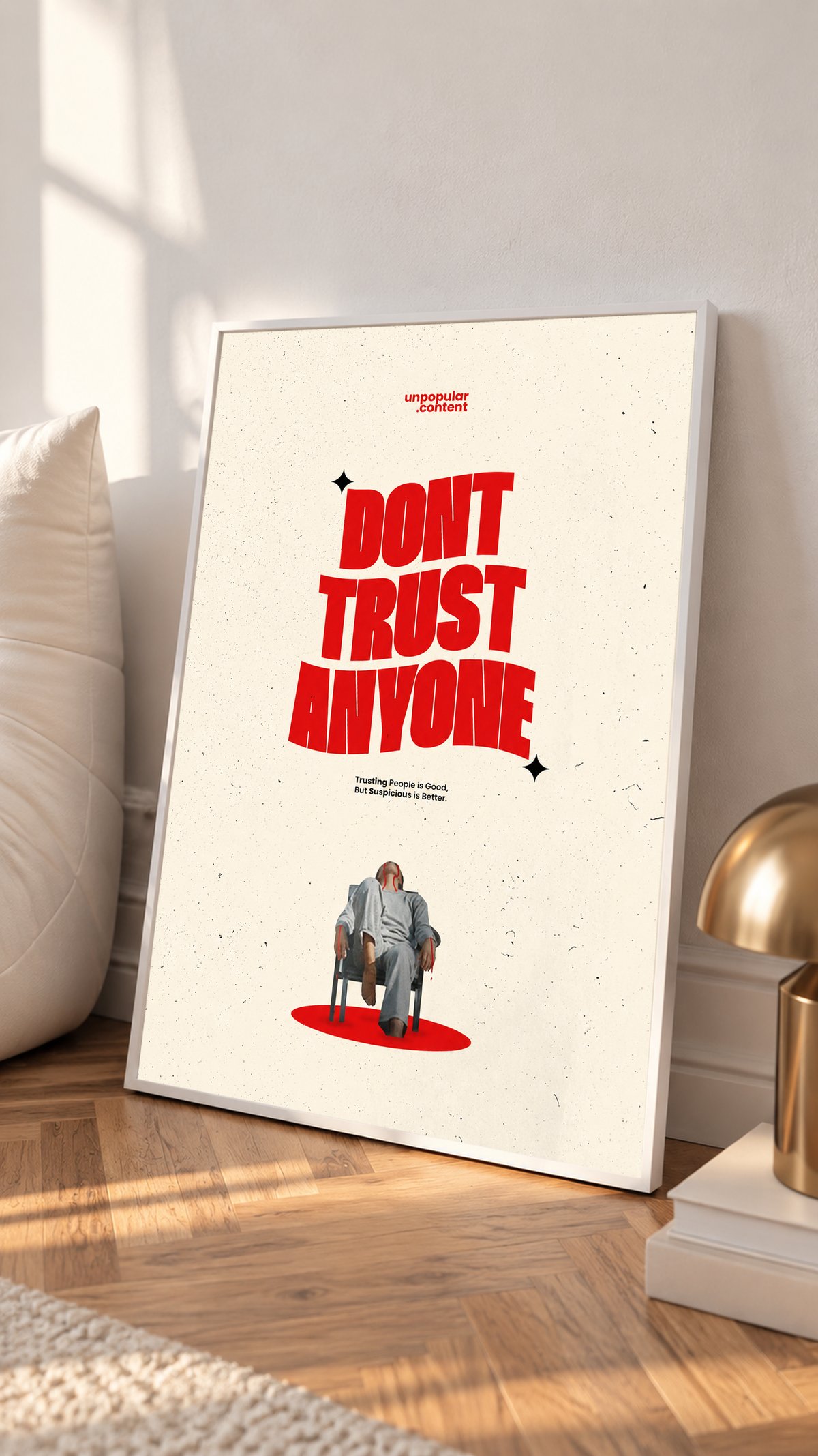 Bold red Don't Trust Anyone typography above a small seated figure on cream in a white frame on a sunlit floor beside a white cabinet