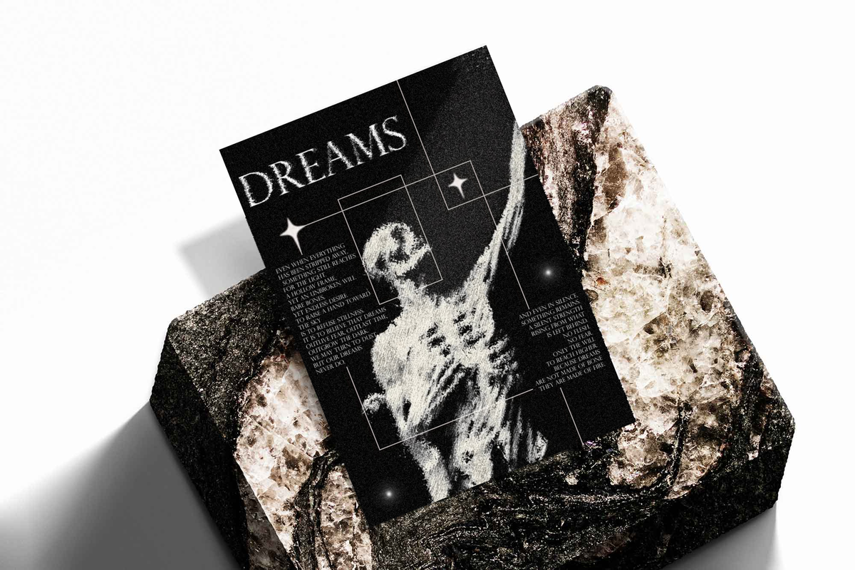 Unframed artwork depicting ghostly human figure with an outstretched arm and DREAMS typography, presented diagonally on rough stone.