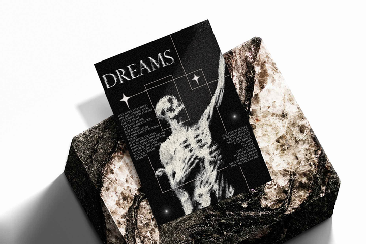 Unframed artwork depicting ghostly human figure with an outstretched arm and DREAMS typography, presented diagonally on rough stone.