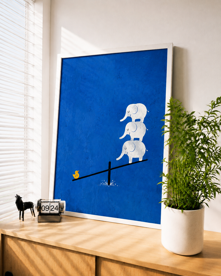 White-framed blue wall art: three white elephants on a seesaw with yellow coin