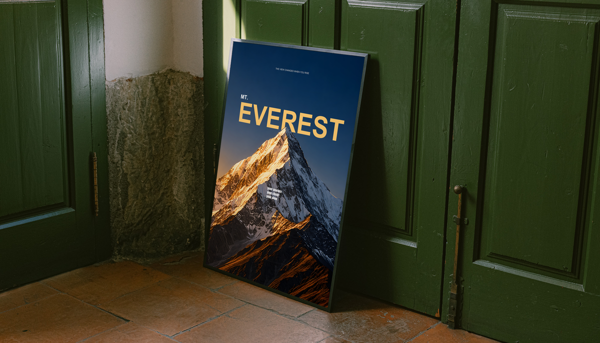 Golden light on a snowy Everest summit with yellow lettering on dark navy; unframed canvas styled by a green doorway