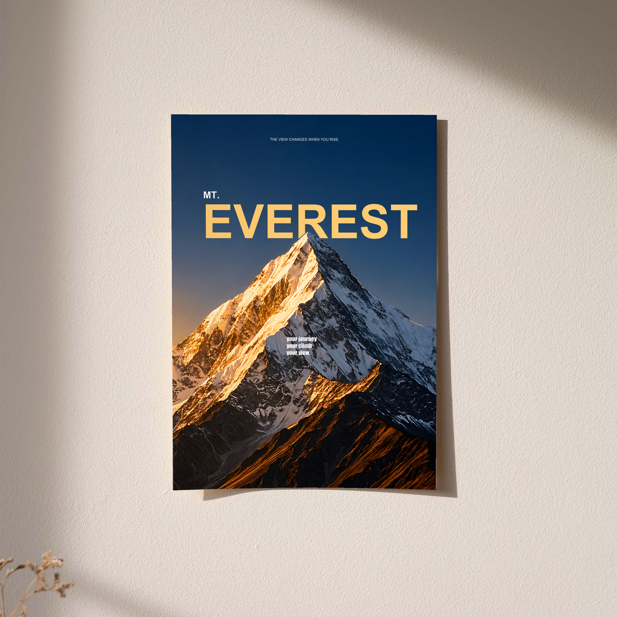 Golden light on a snowy Everest summit with yellow lettering on dark navy; unframed print on a wall