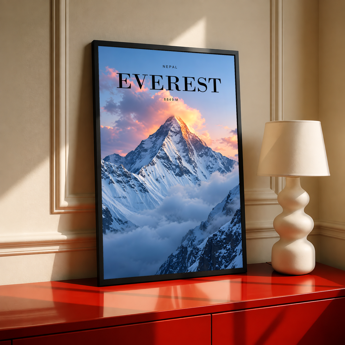 Snowy Everest peak rising through pink sunrise clouds; black framed print on a red cabinet