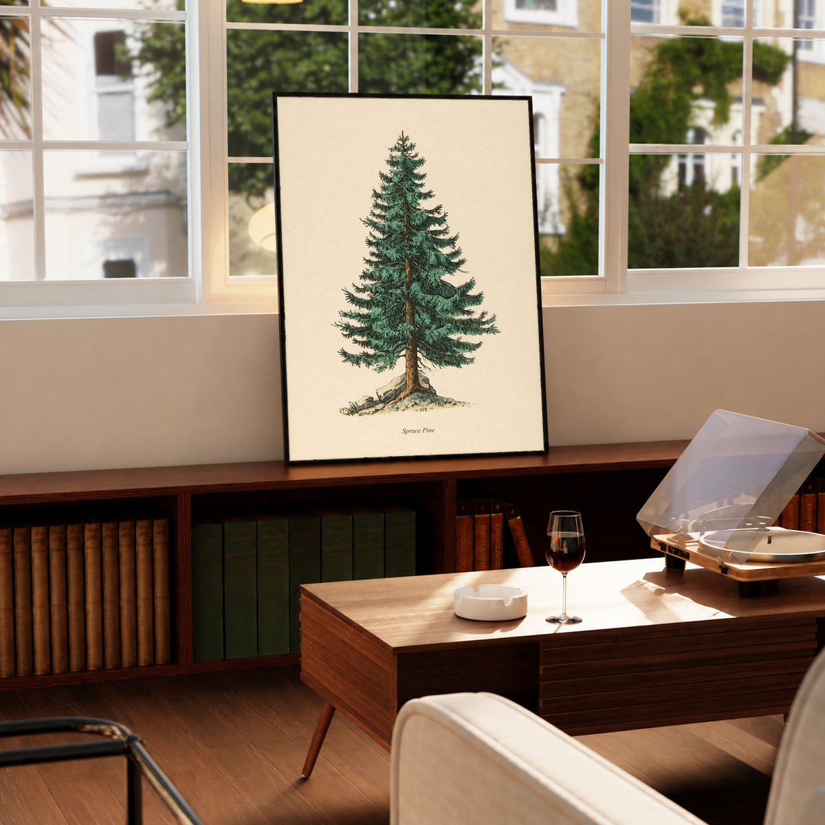 Single green evergreen tree on cream with a printed Spruce Pine caption in a black frame on a wooden cabinet beside a window and record player