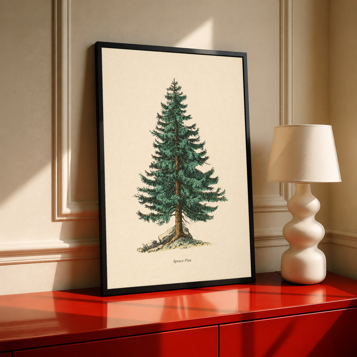 Single green evergreen tree on cream with a printed Spruce Pine caption in a black frame on a red cabinet beside a cream lamp