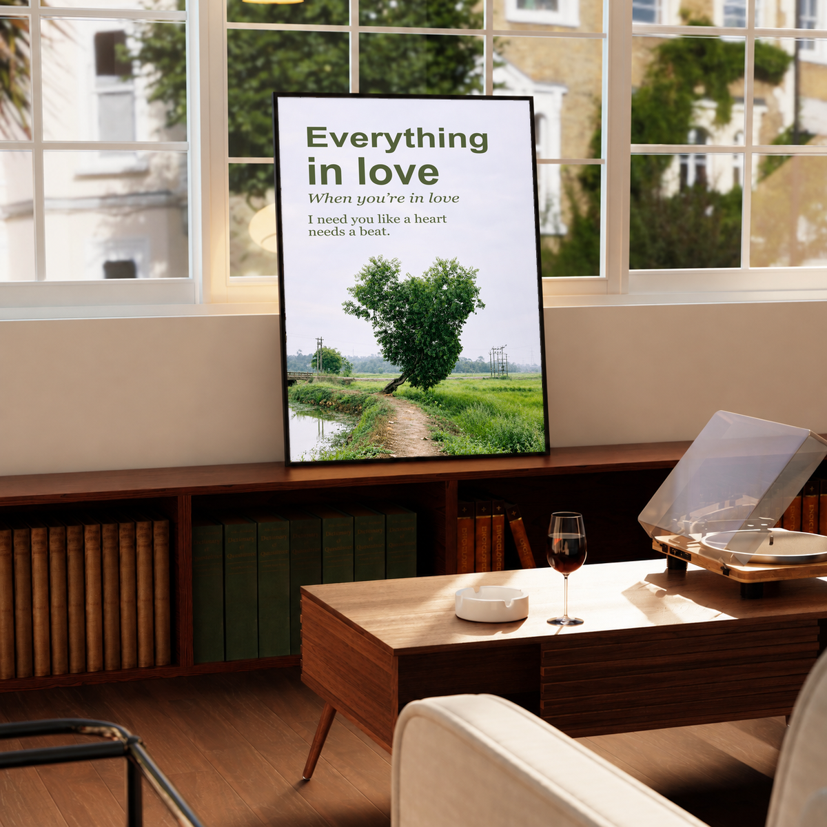 Heart-shaped green tree beside a rural path with Everything in Love lettering; framed print beside a window