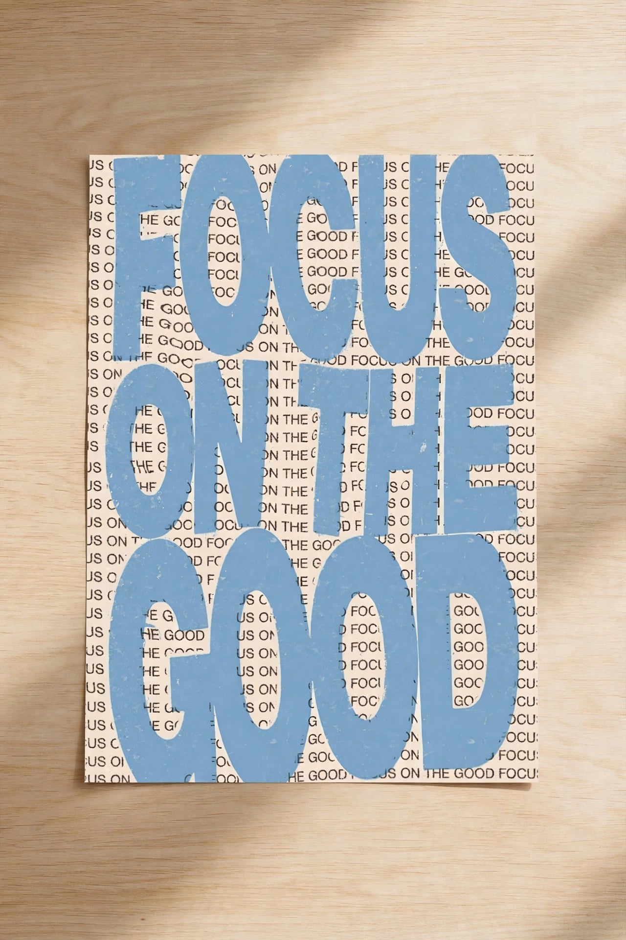 Blue typographic wall print reading “FOCUS ON THE GOOD”