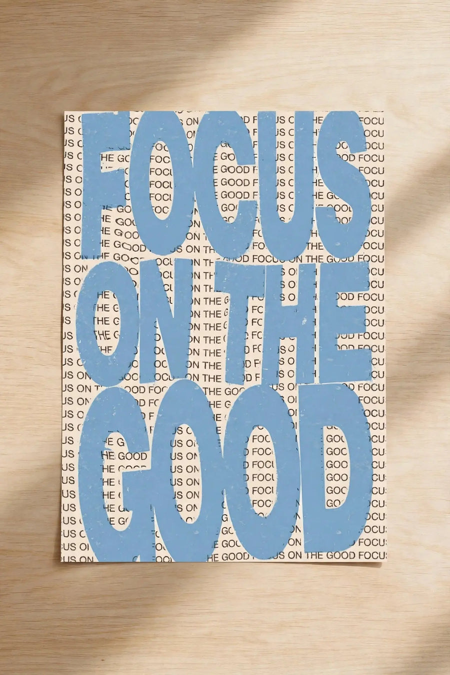 Blue typographic wall print reading “FOCUS ON THE GOOD”