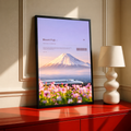 White bullet train below Mount Fuji with pink cosmos flowers; black framed print on a red cabinet
