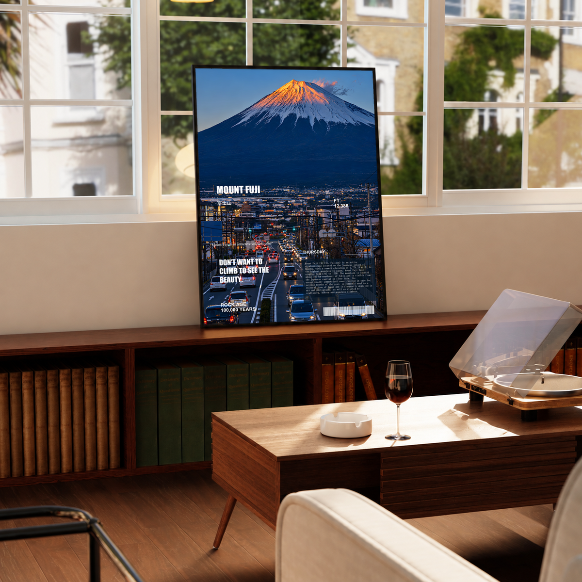 Orange-lit Mount Fuji above a deep blue city in an editorial collage; framed print beside a window