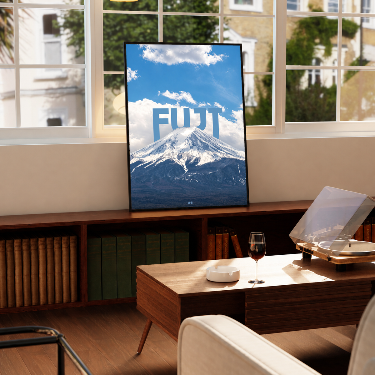 Snow-covered Mount Fuji beneath blue sky and large white FUJI lettering; framed print beside a window
