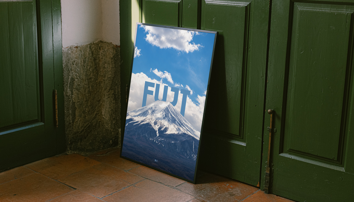 Snow-covered Mount Fuji beneath blue sky and large white FUJI lettering; unframed canvas styled by a green doorway