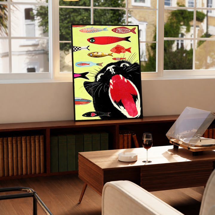Framed cat-and-fish poster standing on a wooden mantel near a window